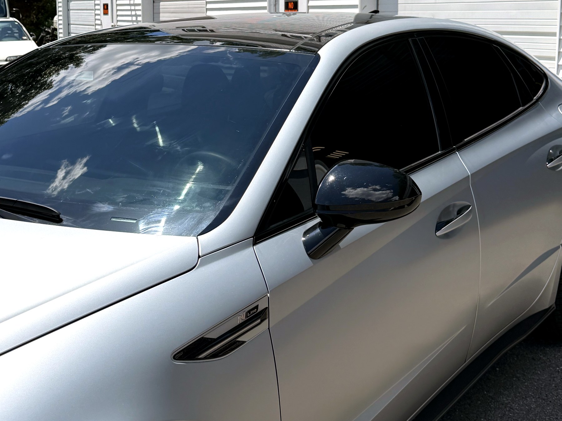 Matte silver sedan with gloss black roof and mirror showing a vinyl color-change wrap installed at Imperial Car Tint
