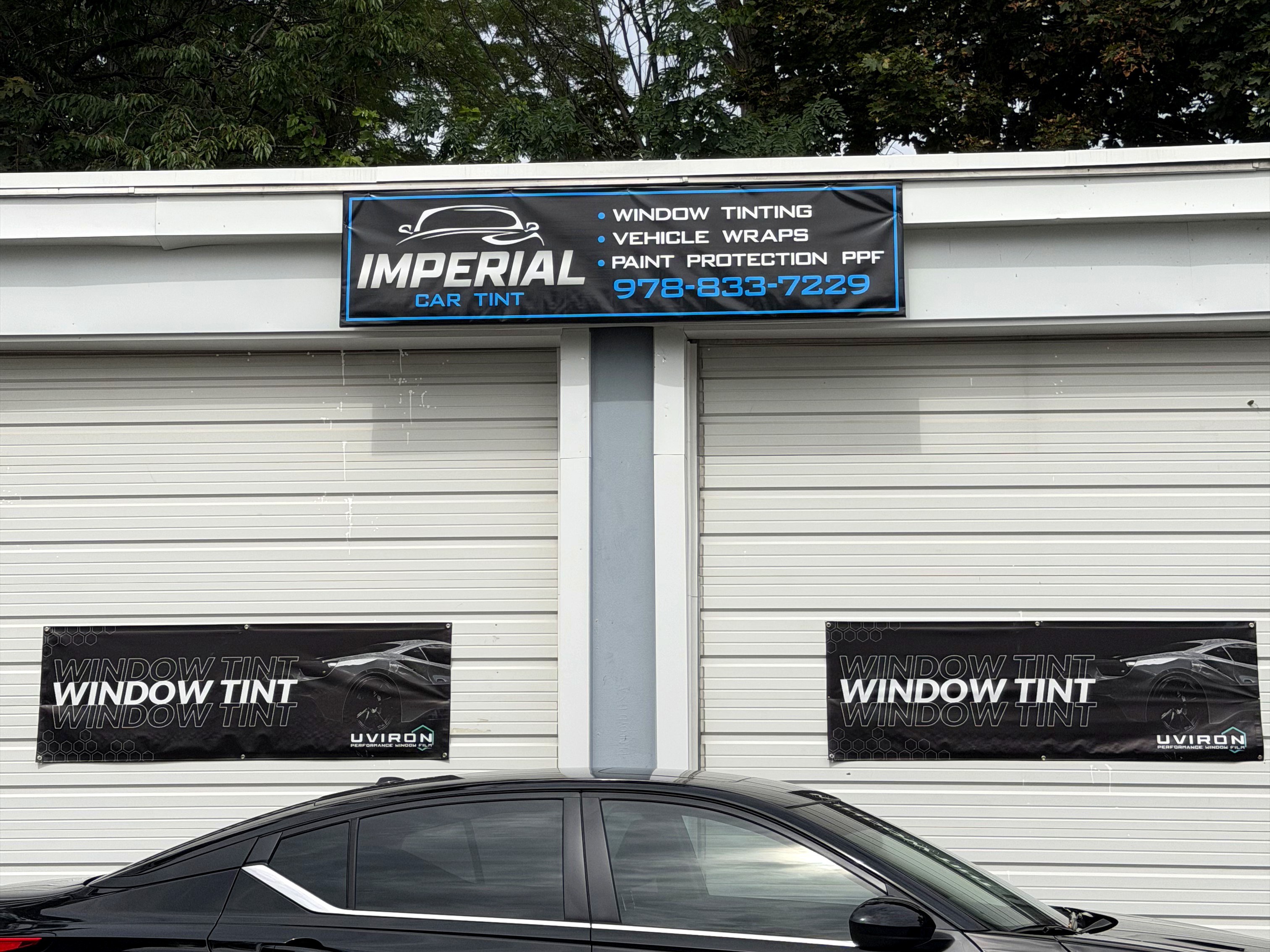 Freshly tinted black sedan outside the Imperial Car Tint shop